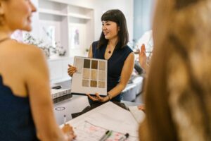 pexels-photo-7490849-7490849 Interior designer presenting color swatches to clients in a modern workspace, fostering a creative atmosphere.